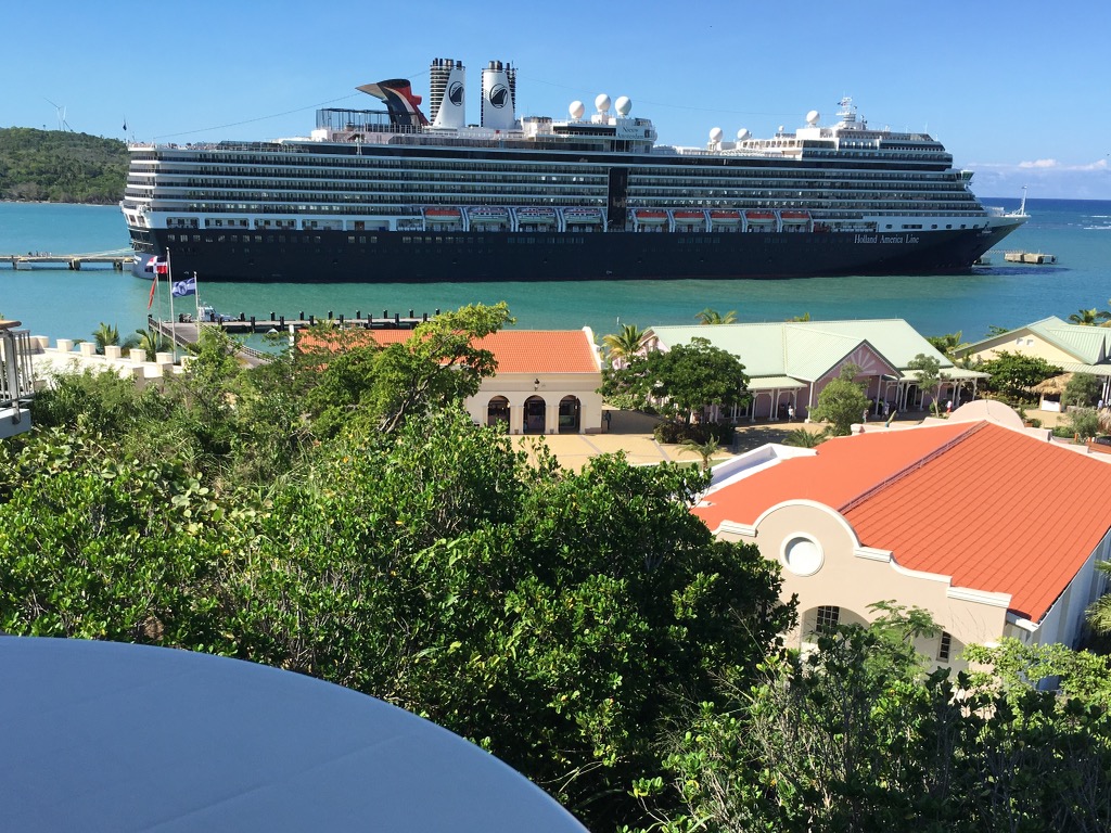 Une vue terrestre d'un bateau de croisière sur l'océan avec de nombreuses villas entourées d'arbres verdoyants.