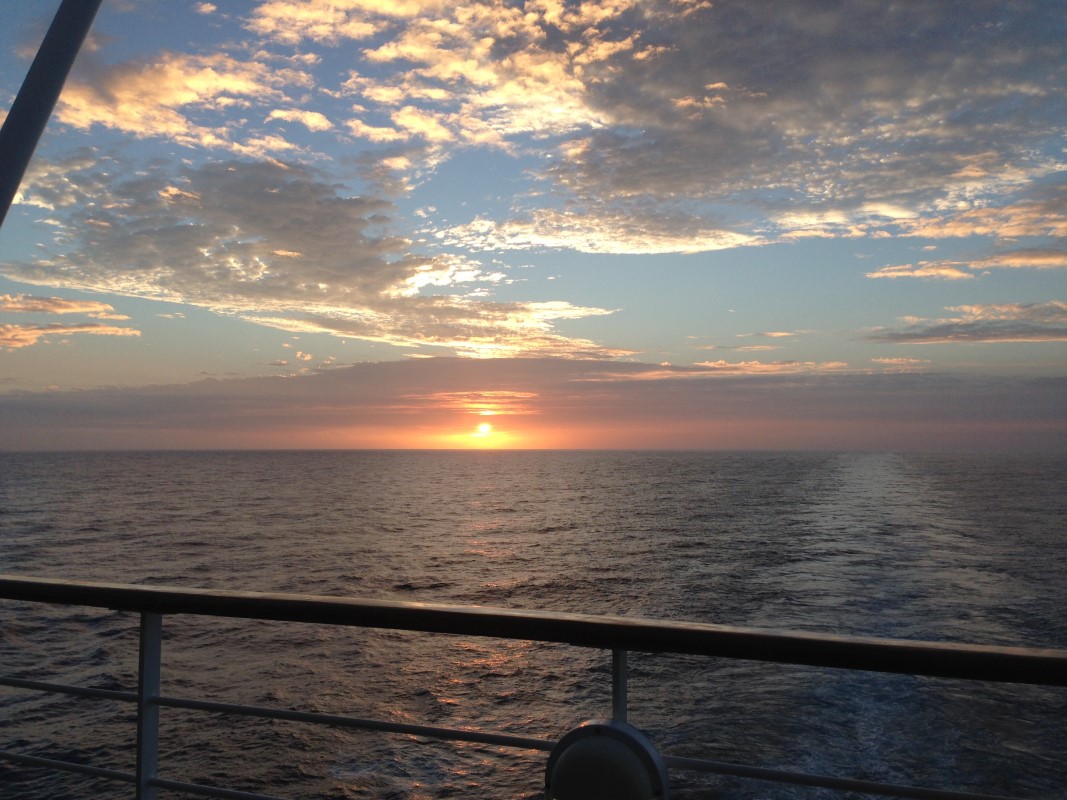 Photo d'un lever de soleil hawaïen aux teintes orange depuis un bateau de croisière.
